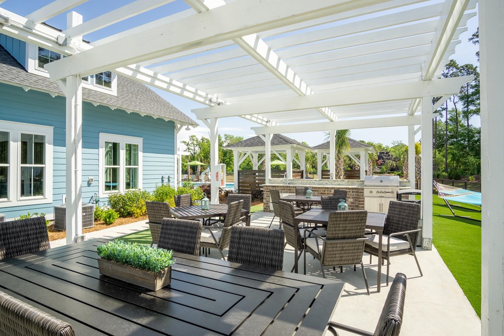 a patio with tables and chairs under a white roof