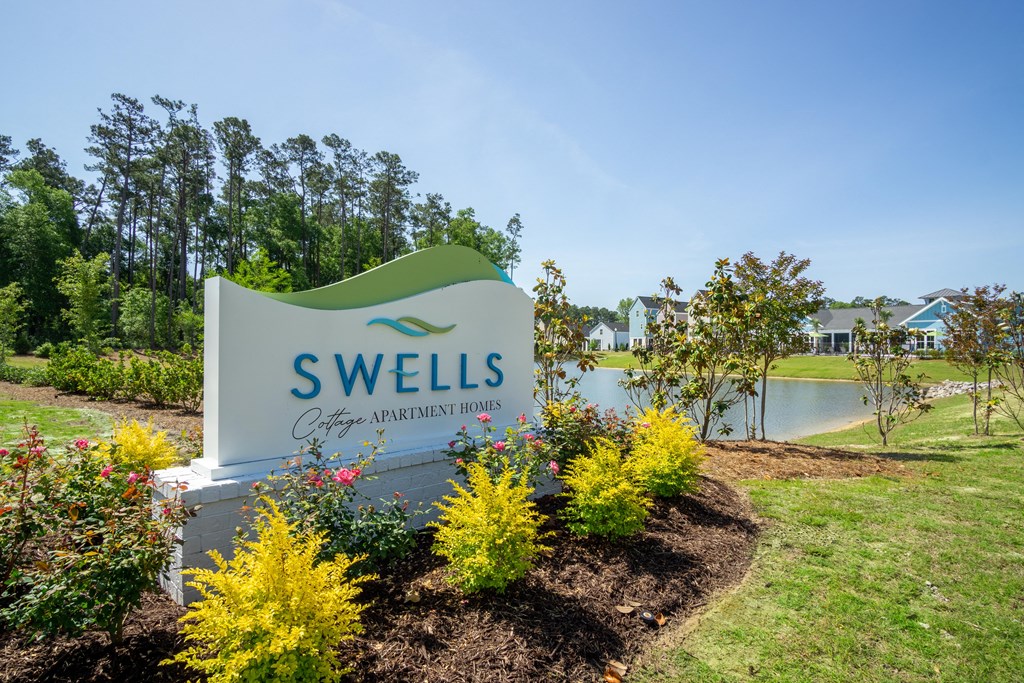 a sign for swells apartments with a lake in the background