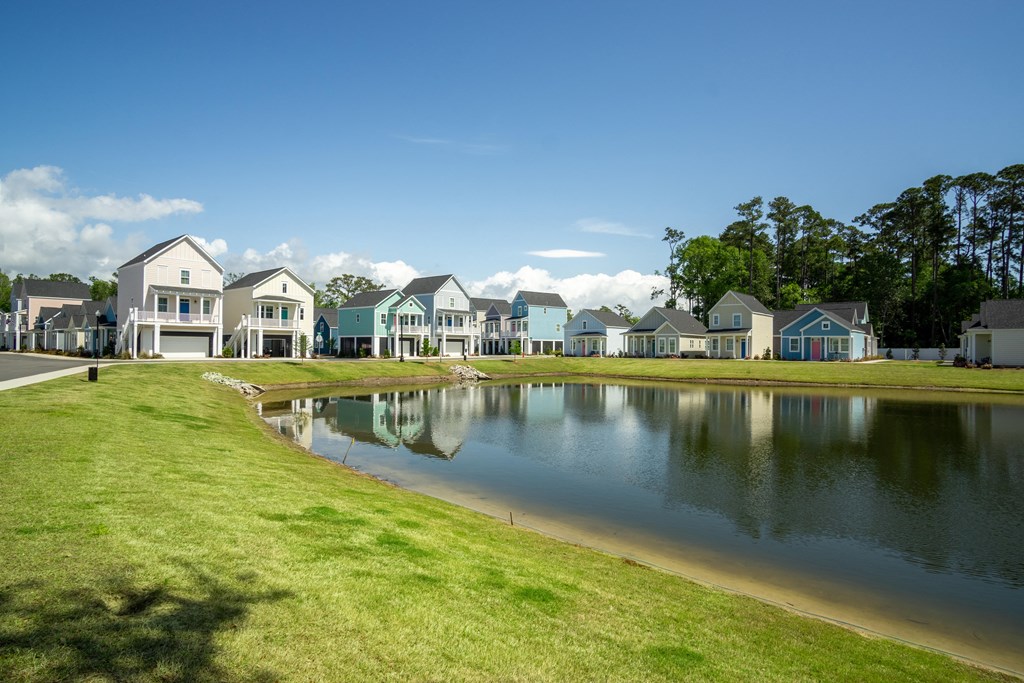 a pond in front of a row of houses