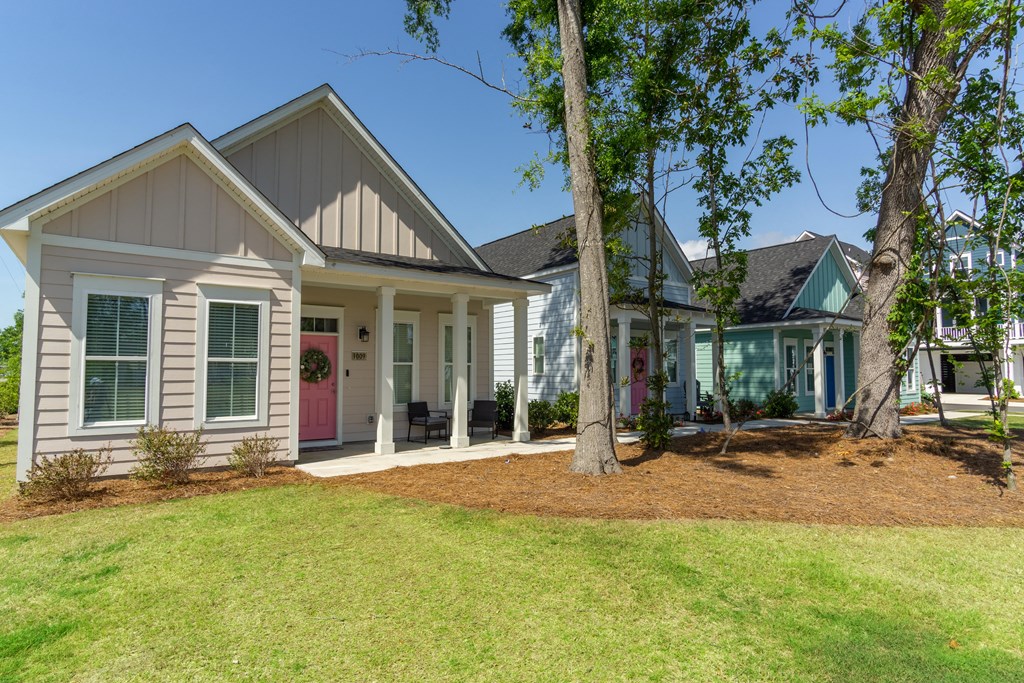 a house with a lawn and trees in front of it