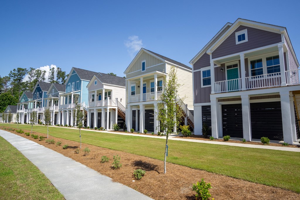 a row of town homes with lawns and trees in front of them