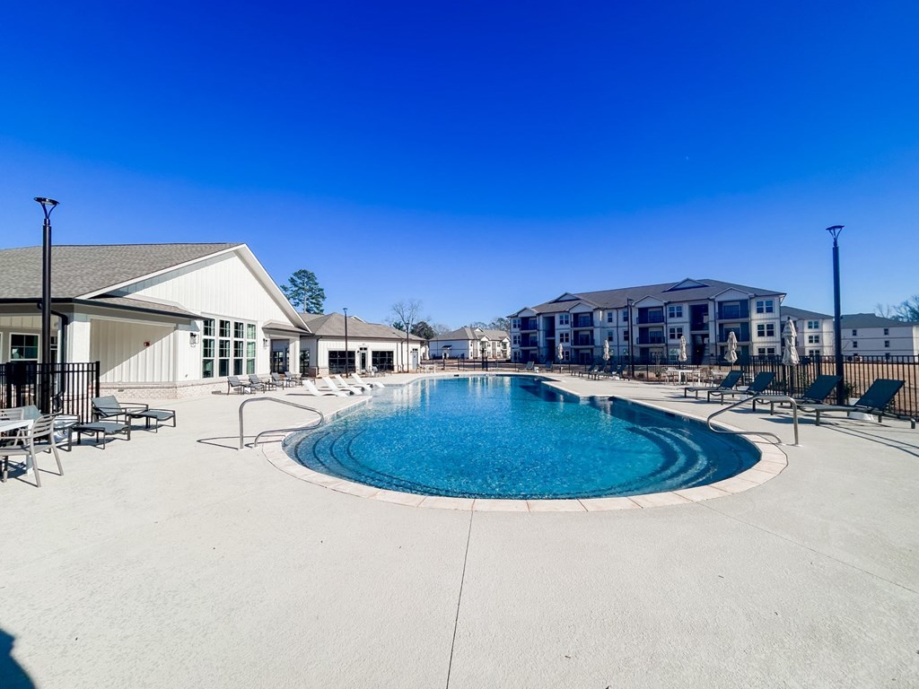 Resort-style pool with lounge chairs at luxury Opelika apartment community