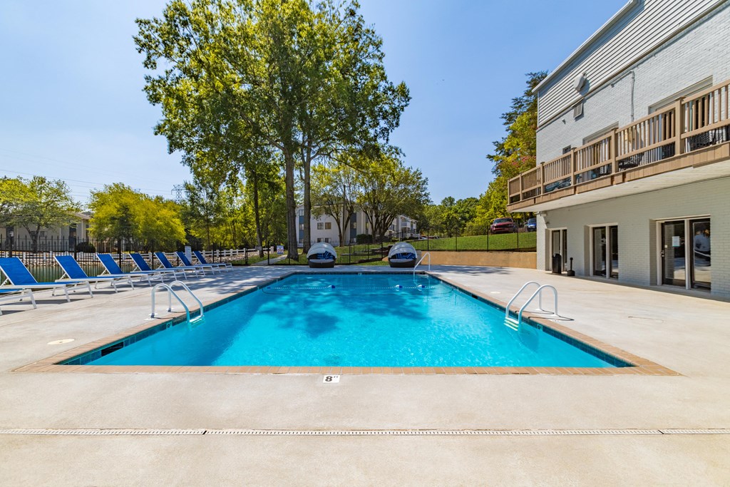 A large outdoor swimming pool with a slide and sun loungers at Enclave at 38 Twenty Two Apartments in Greensboro, NC