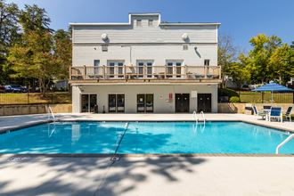 a swimming pool in front of a house with a pool