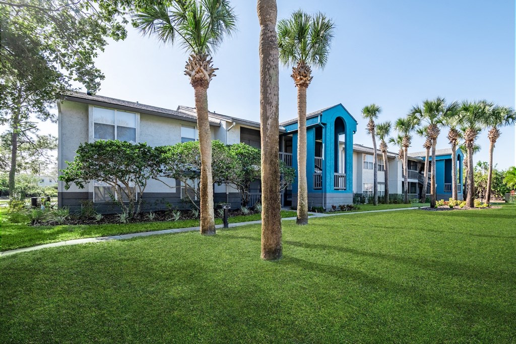 a building with blue pillars and palm trees in front of it