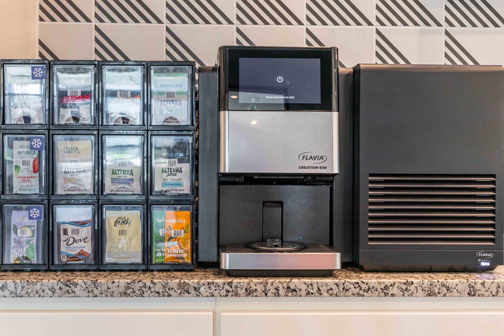 a coffeemaker and a coffee maker on a counter next to a refrigerator