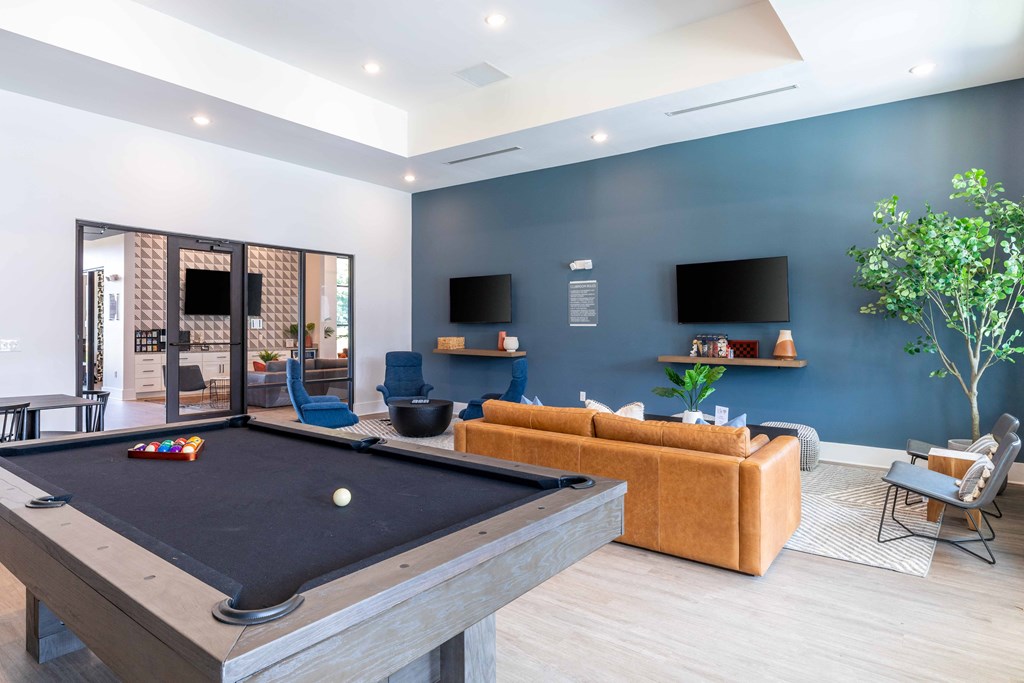 a games room with a pool table and a tv