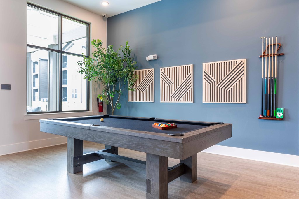 a pool table in a living room with a blue wall