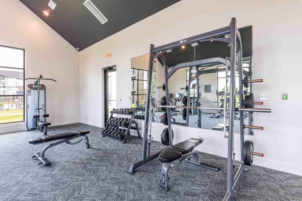 a gym with weights and cardio equipment in a building