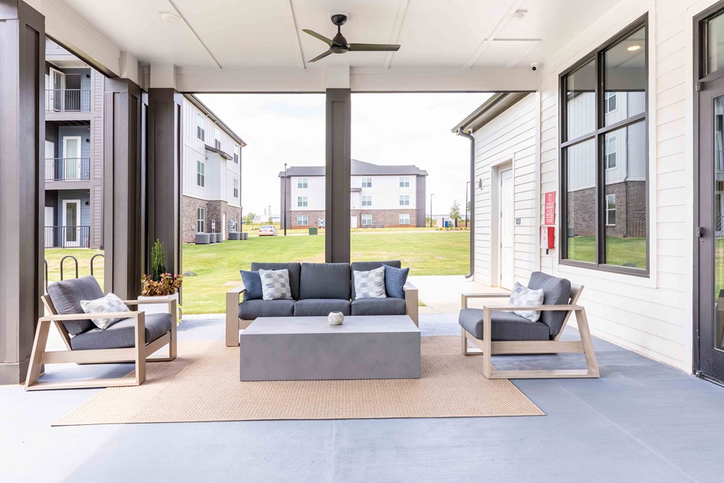a covered patio with couches and chairs and a coffee table