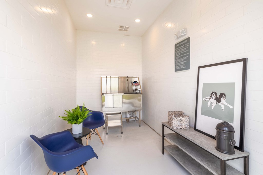 the living room of a home with blue chairs and a desk