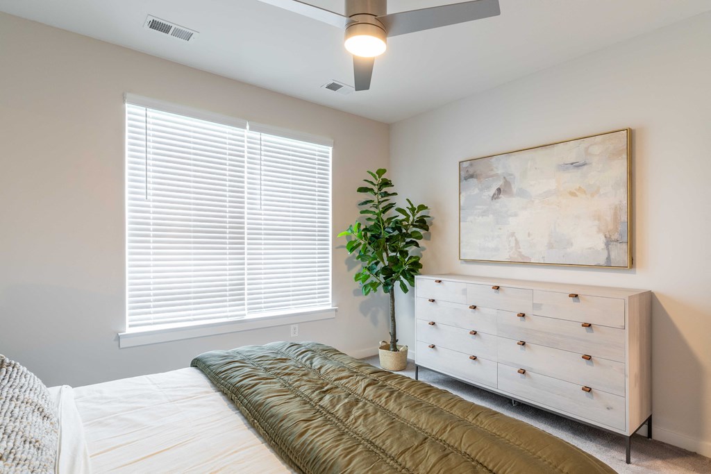a bedroom with a bed and a dresser and a window