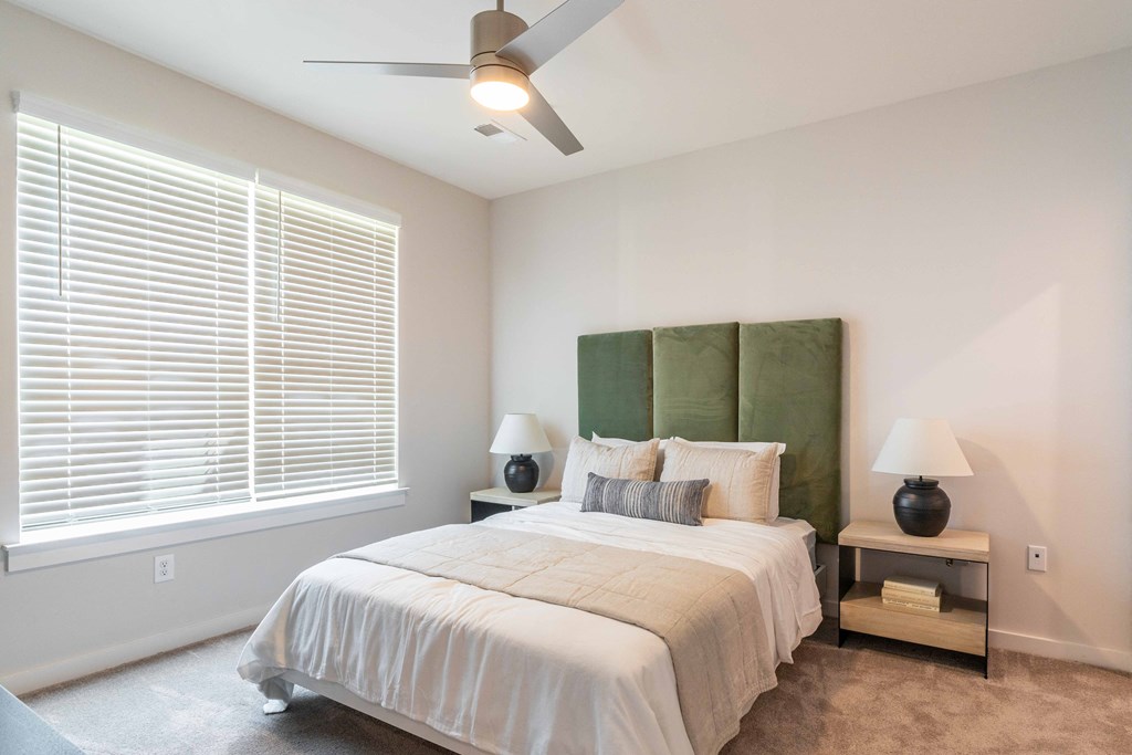a bedroom with a large bed and a ceiling fan