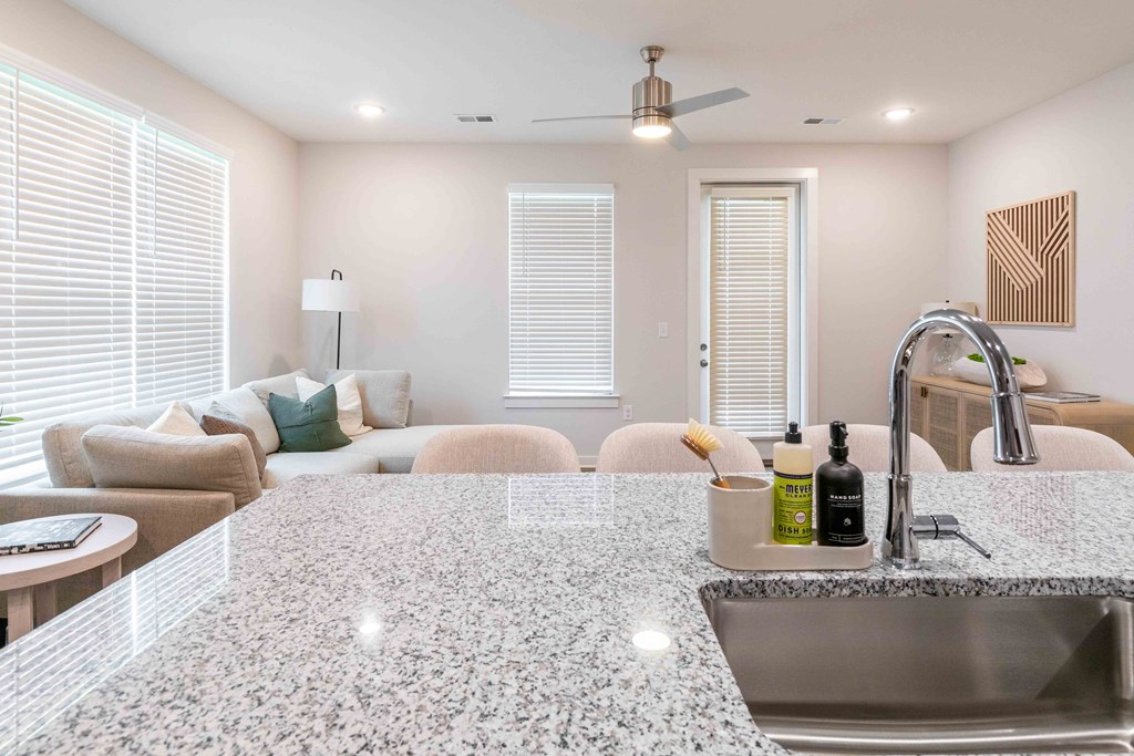 a kitchen with a sink and a view of a living room