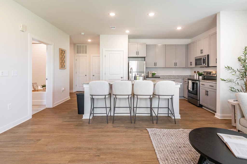 a kitchen and dining room with white chairs and a table