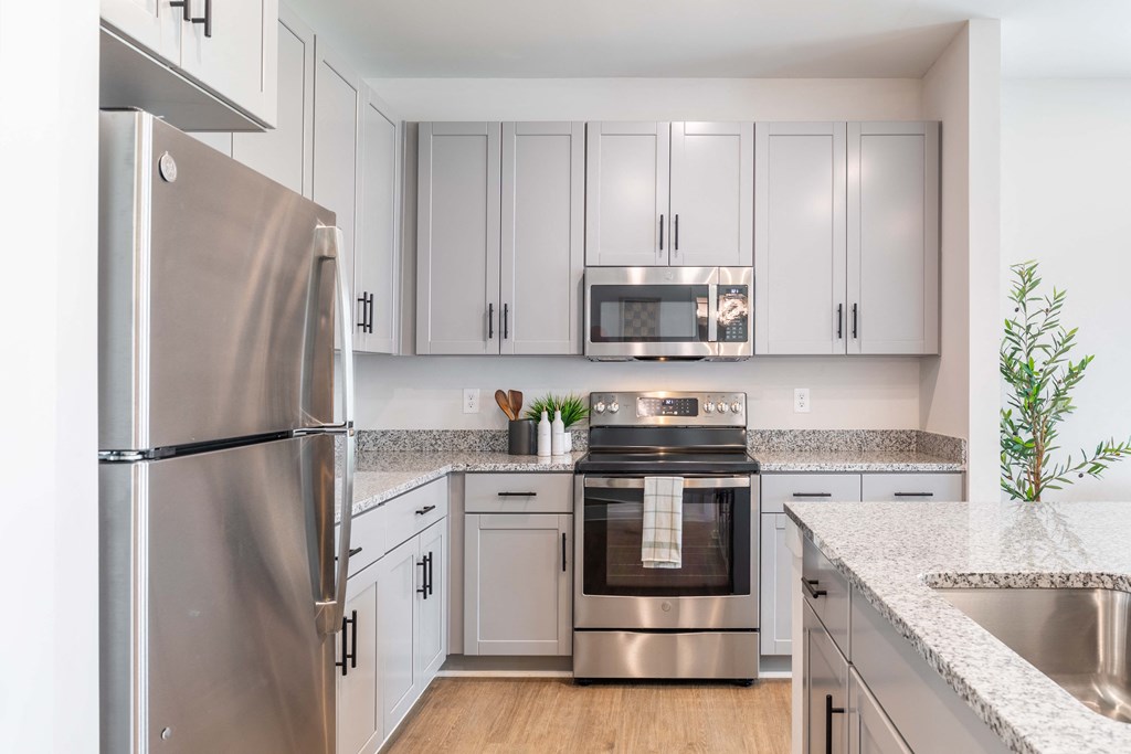 a kitchen with white cabinets and stainless steel appliances