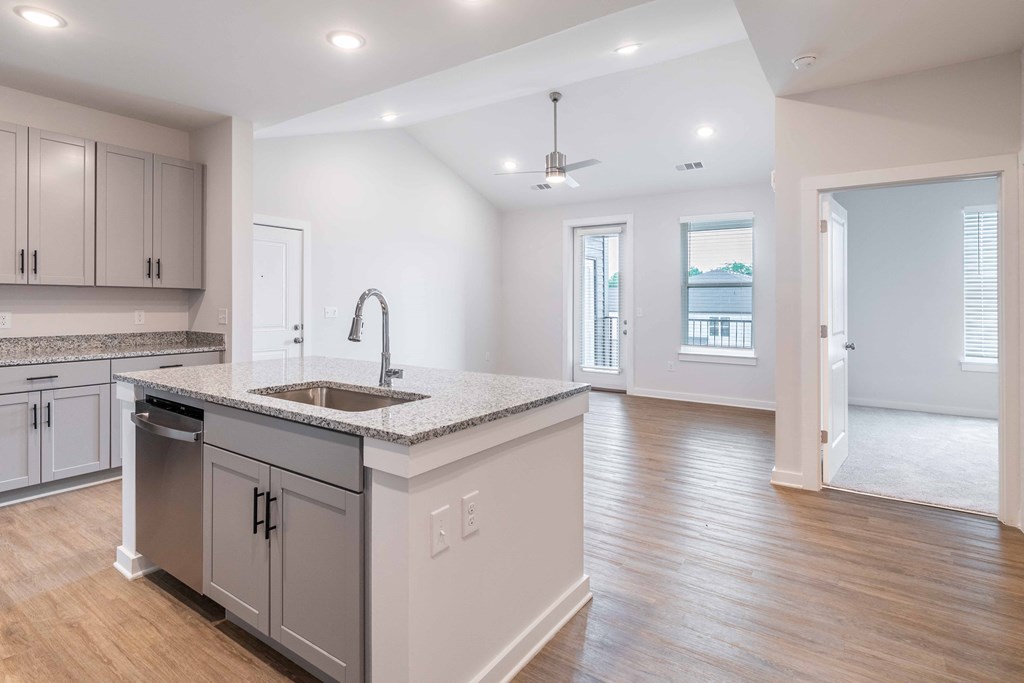 an open kitchen and living room with a sink and counter top