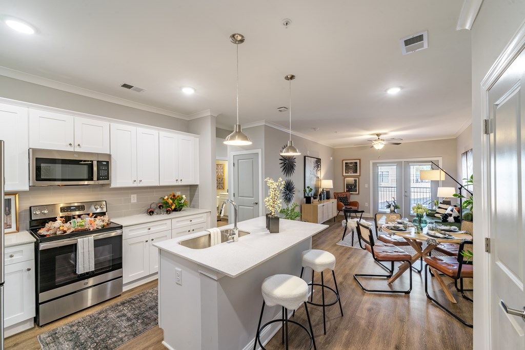 A modern kitchen with white cabinets and stainless steel appliances.