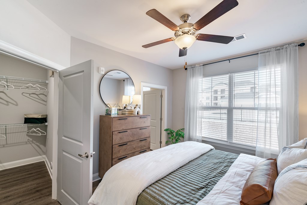 large bedroom with green and white bed and large window