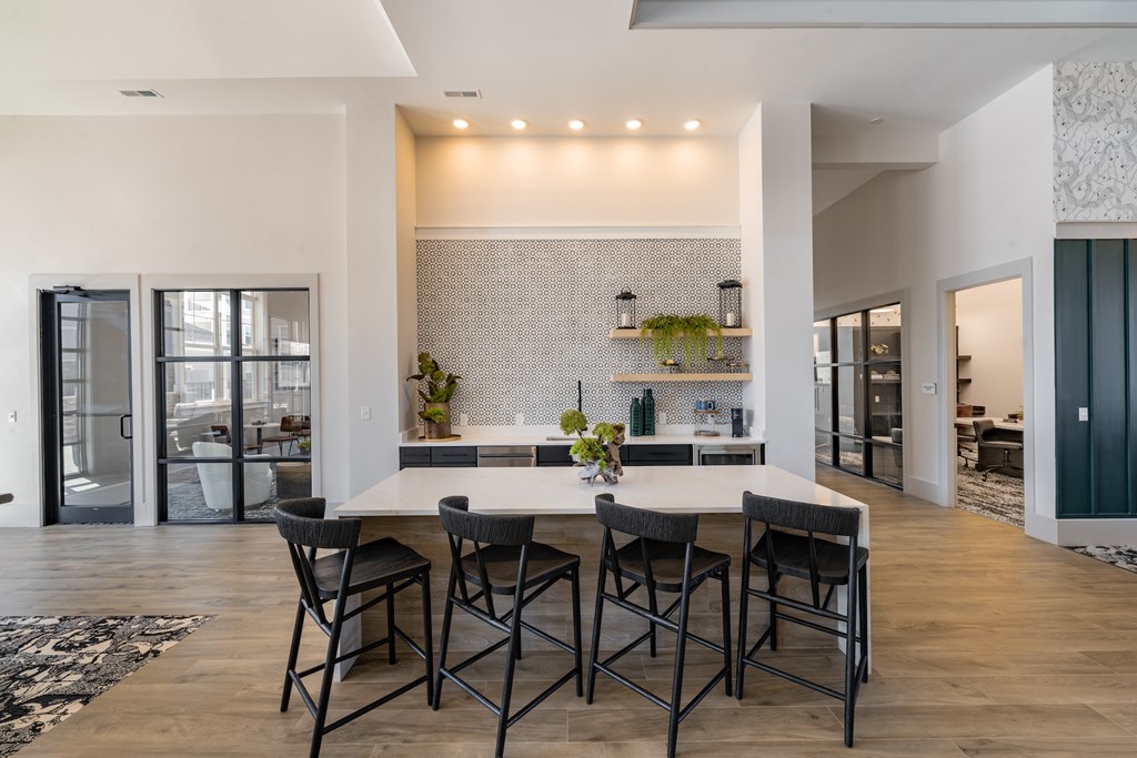 A modern dining room with a white table and chairs.