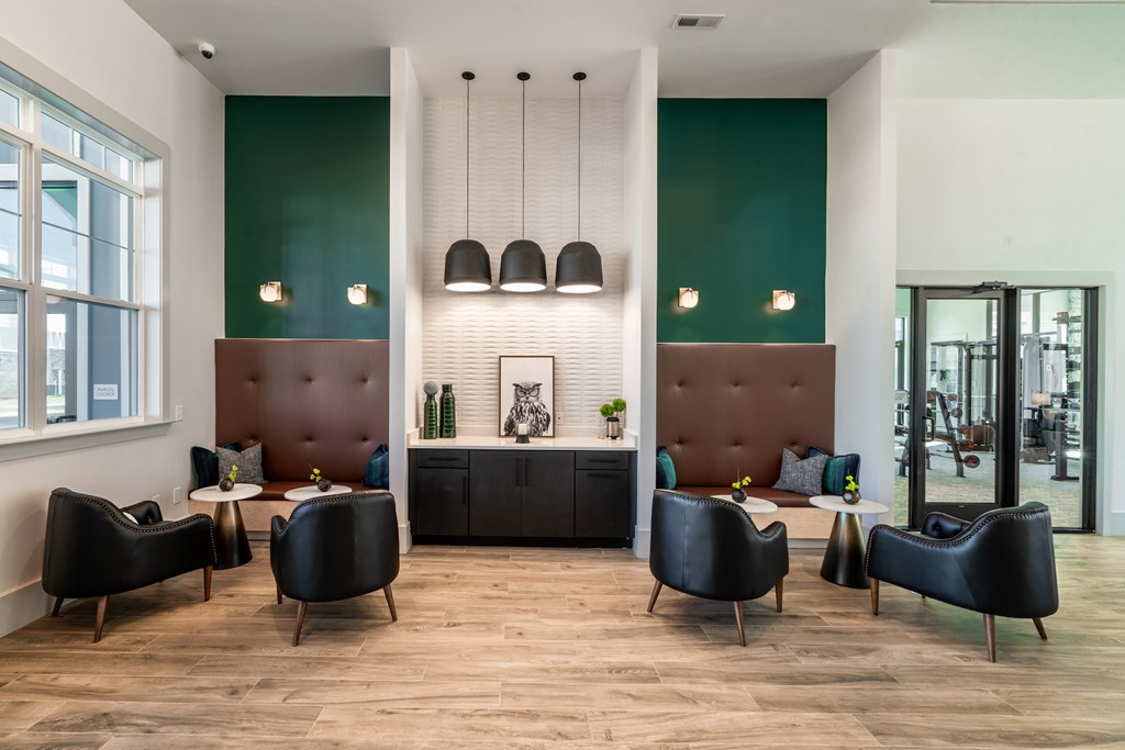 Clubhouse space with green walls and pendant lights with two seating booths