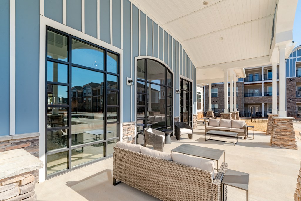A patio with a wicker sofa and a table.