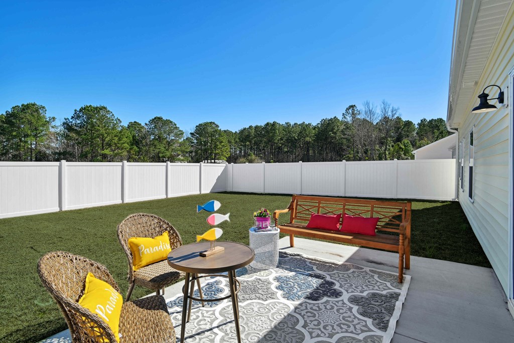 A backyard patio with fence at 15 at Heron apartments in Longs, SC.