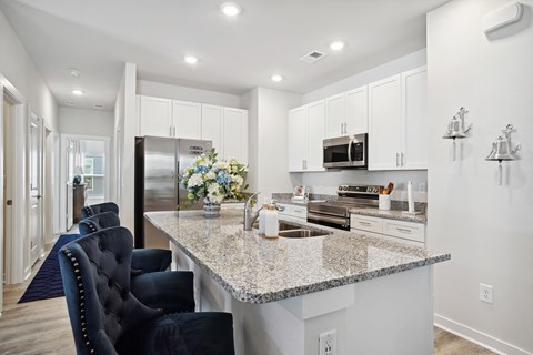 a kitchen with white cabinets and a granite counter top