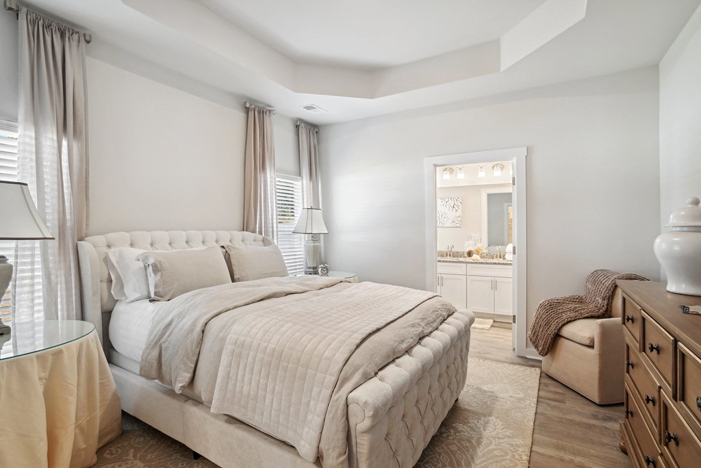 A bedroom with a bed, windows, and bathroom at 15 at Heron apartments in Longs, SC.