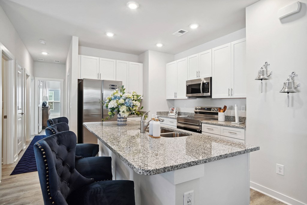 a kitchen with white cabinets and a granite counter top