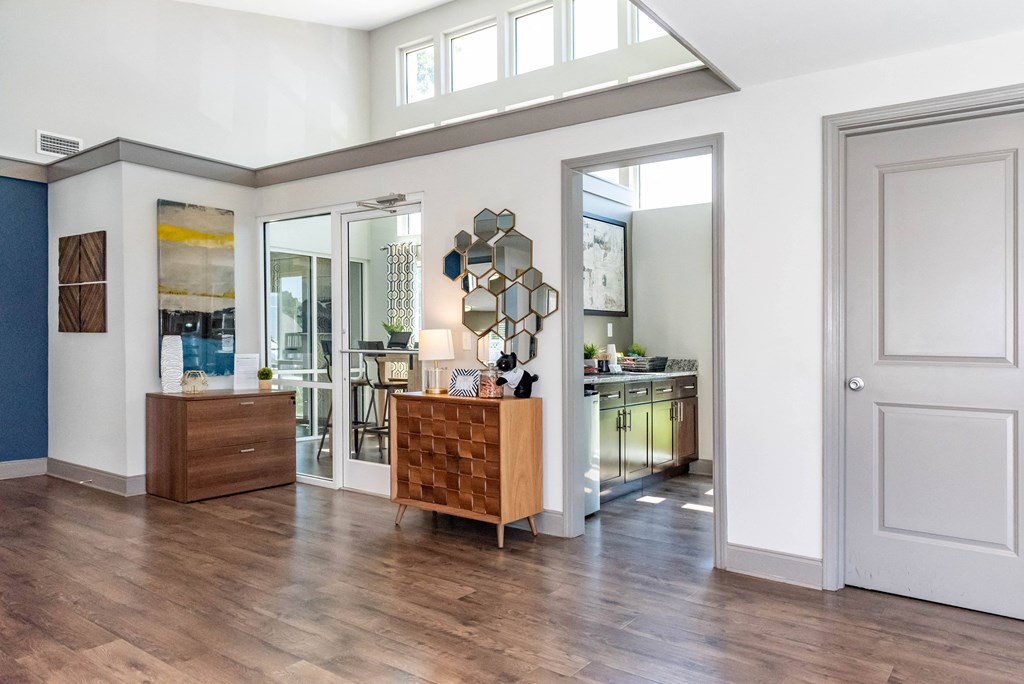 an open living room and kitchen with a wooden floor and white walls