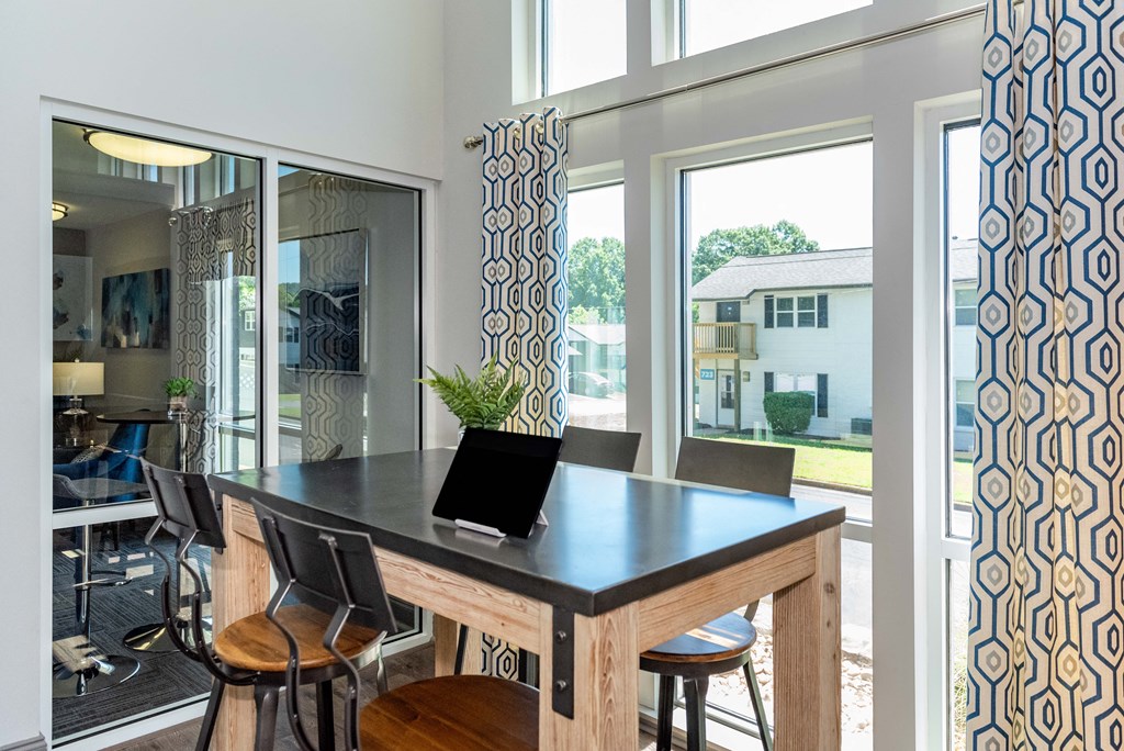 a dining area with a table and chairs and large windows