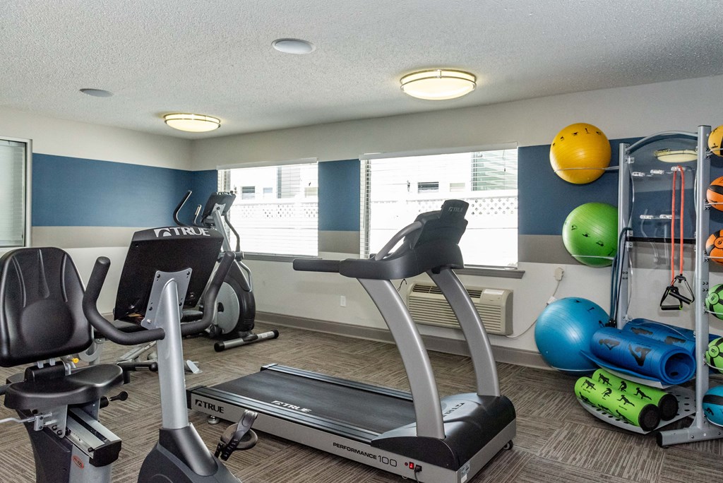 a gym with various exercise equipment at the enclave at university heights