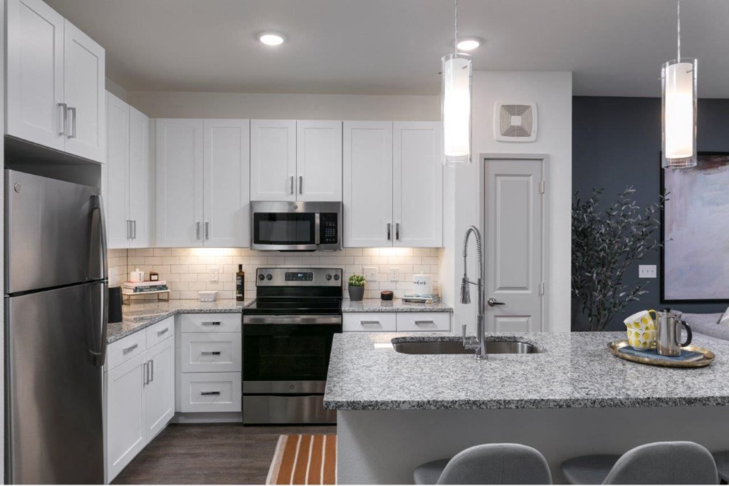 a kitchen with white cabinets and a counter top