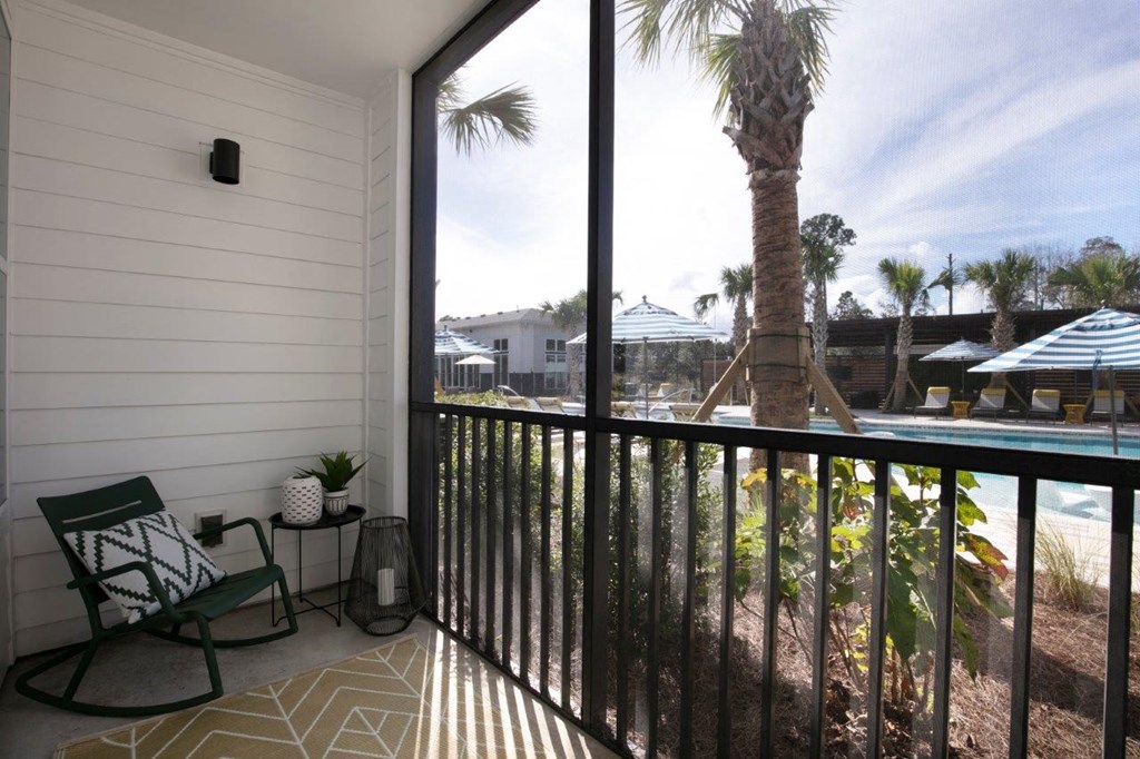 a balcony with a view of a pool and palm trees