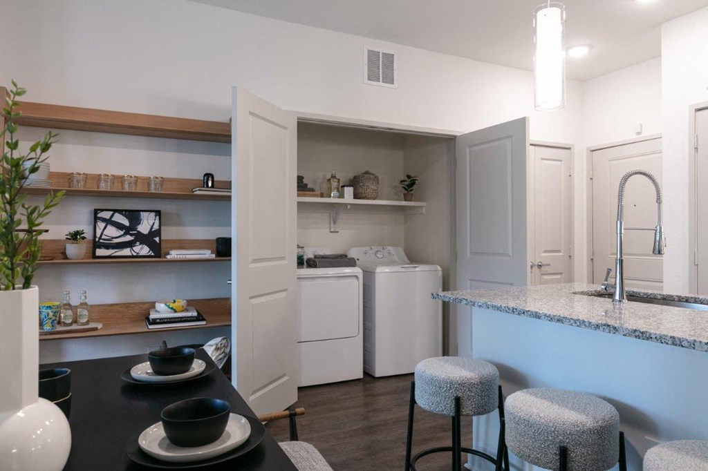 a kitchen with a counter and a sink and a laundry room