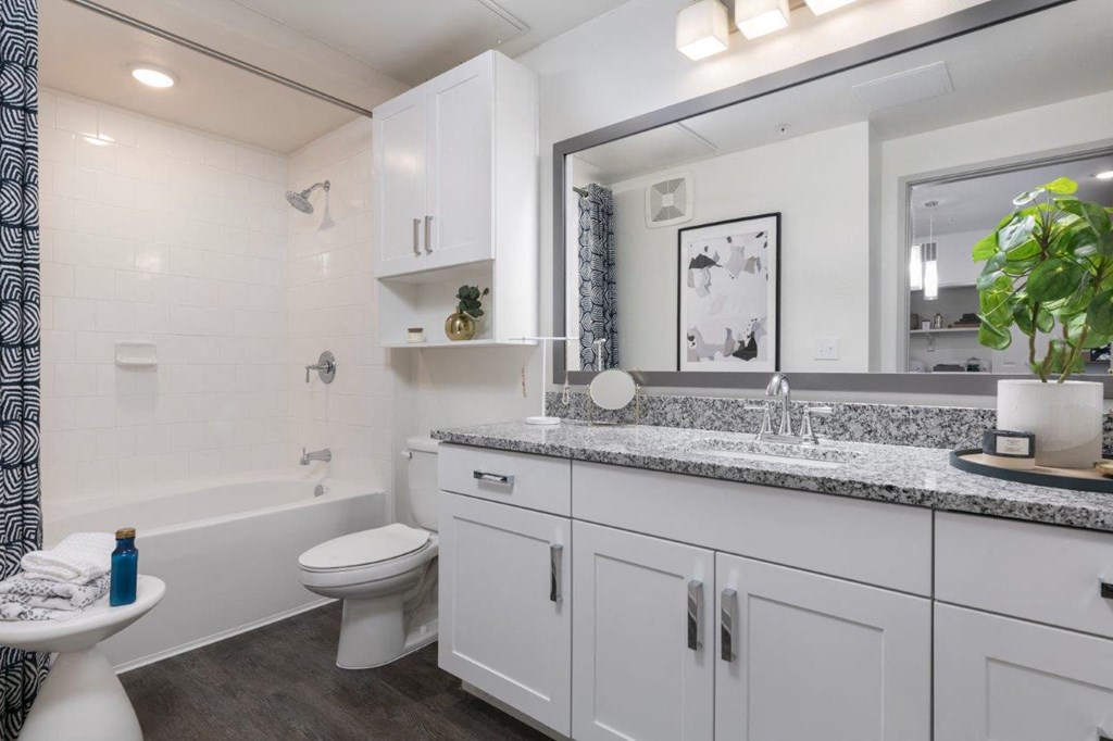 a white bathroom with a large mirror and a toilet