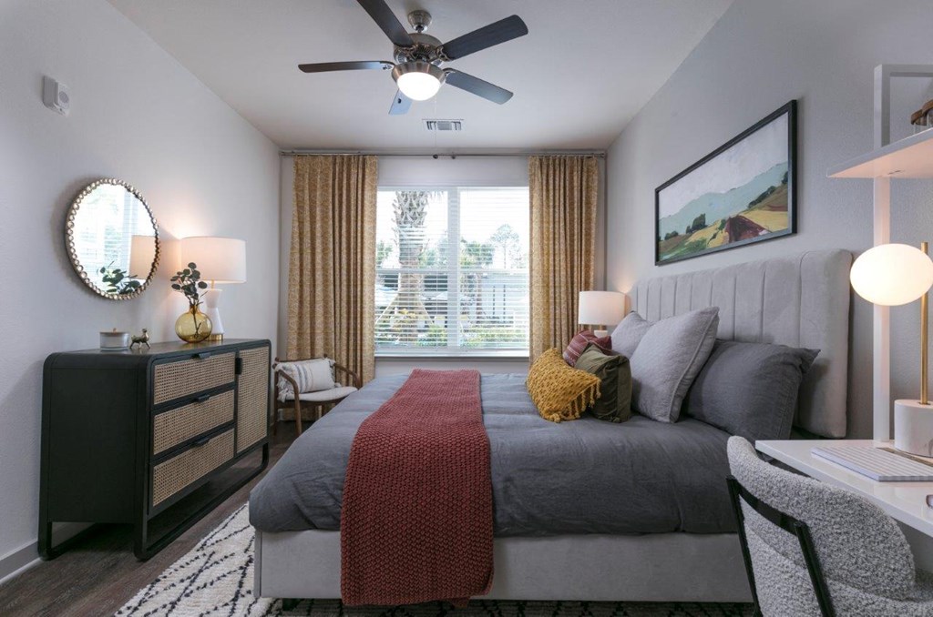 a bedroom with a bed and a ceiling fan