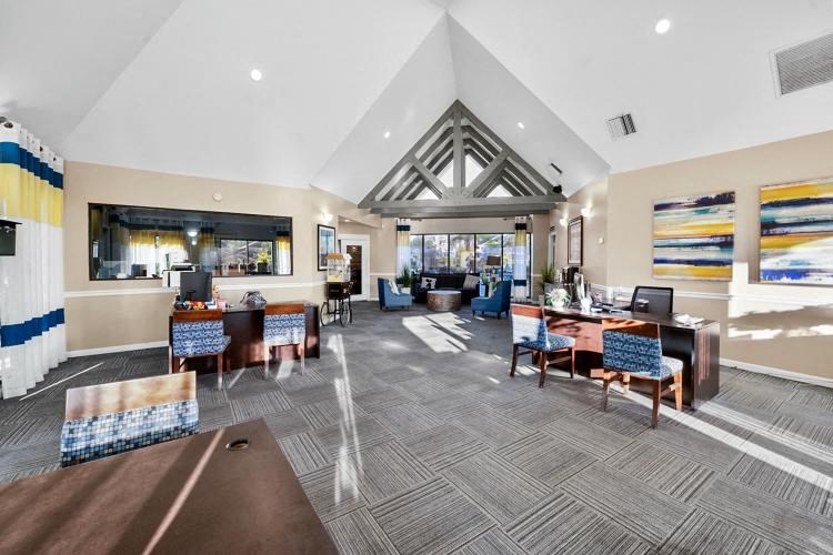 a lobby of a hotel with tables and chairs