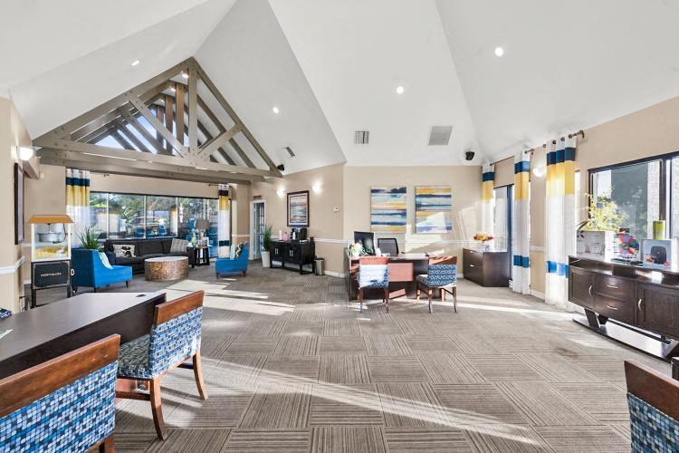 a lobby of a hotel with tables and chairs