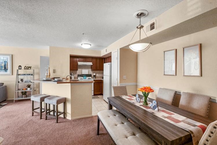 a living room and kitchen with a table and chairs