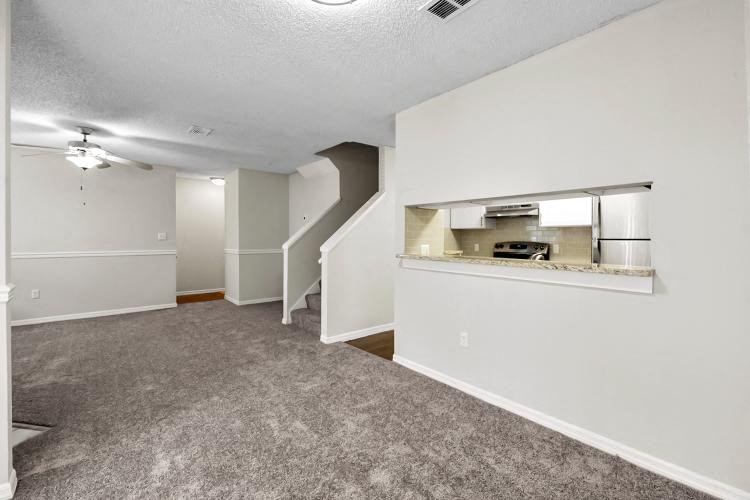 an empty living room with a kitchen in it