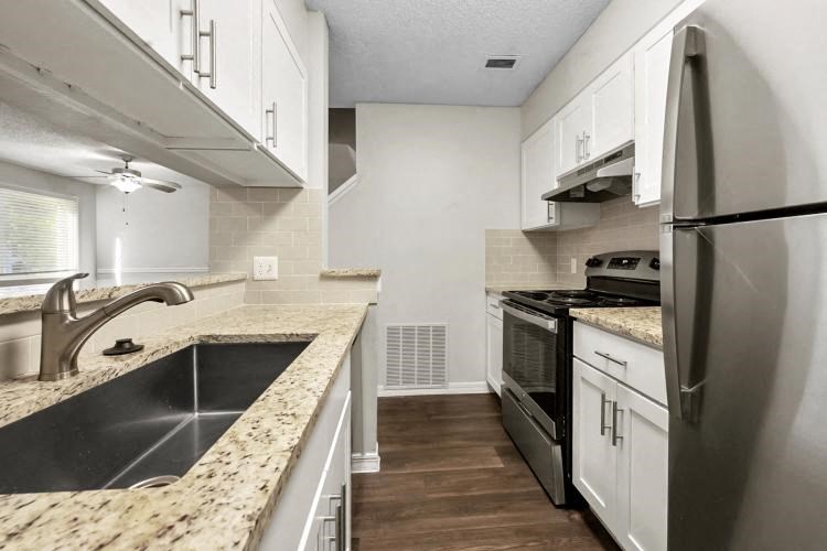 a kitchen with stainless steel appliances and marble counter tops