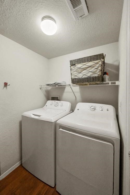 a white laundry room with two washes and a dryer