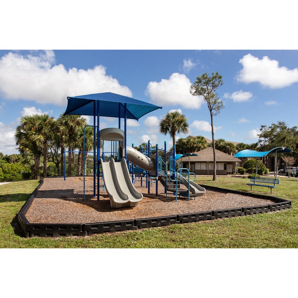 a playground with a slide and umbrella
