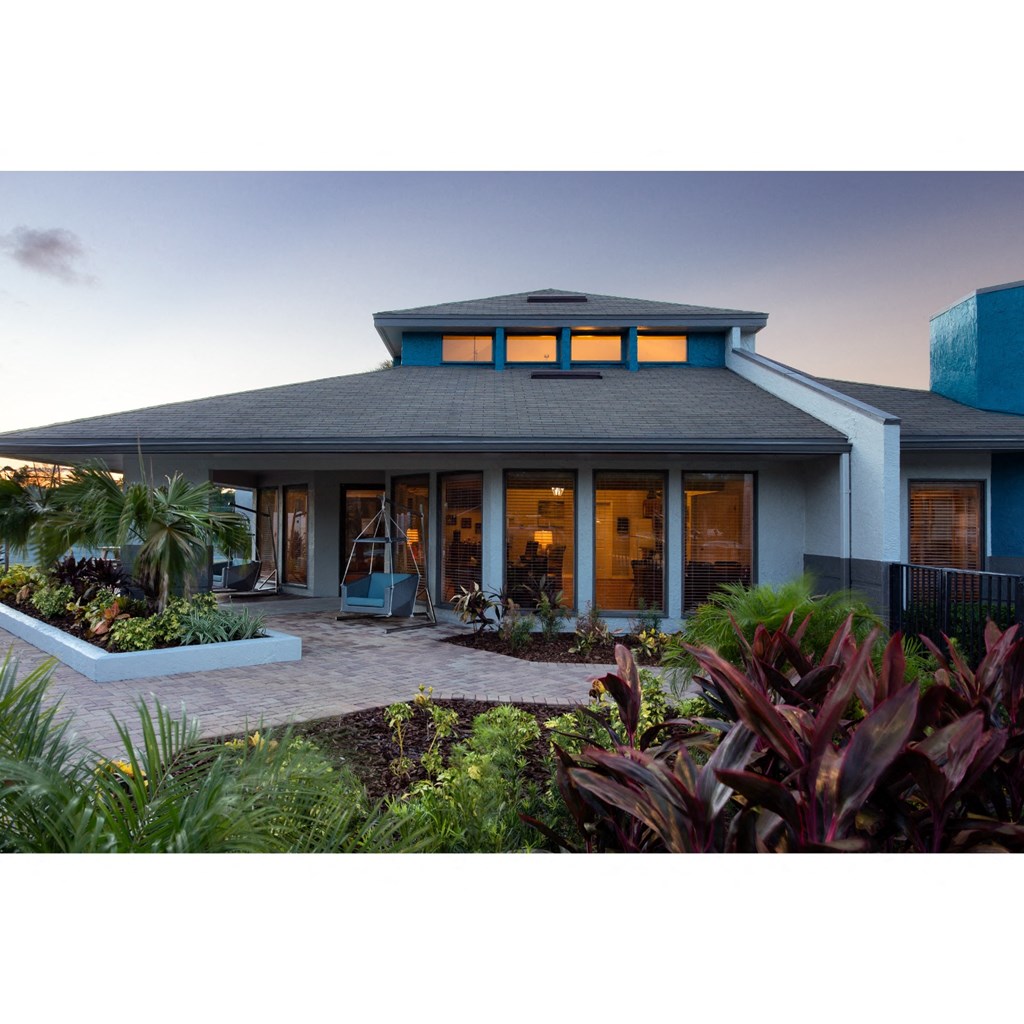 a view of the front of a house with tropical plants