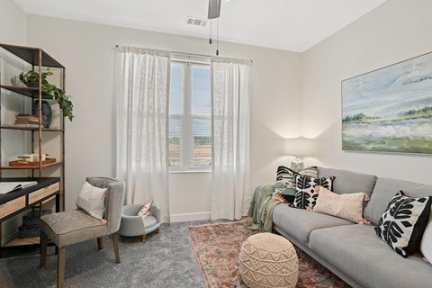 a living room with a couch and a chair and a window