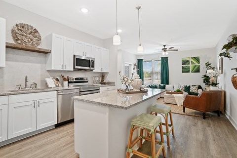 an open kitchen and living room with an island and stools
