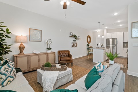 a living room with a couch and a chair and a kitchen