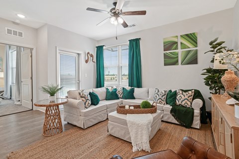 a living room with couches and a table and a ceiling fan